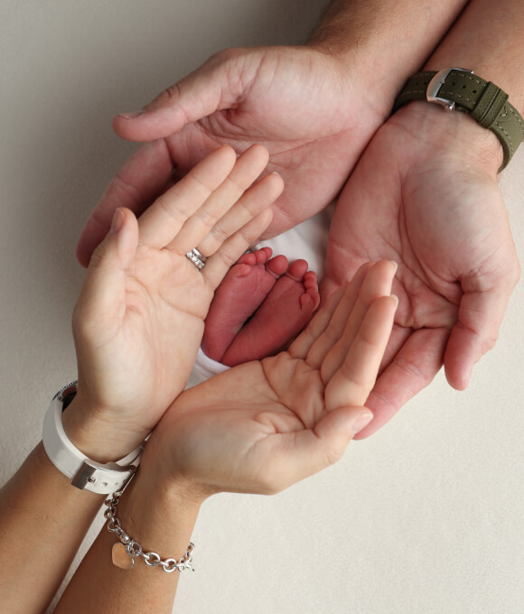 Smiling parents with surrogate after delivery